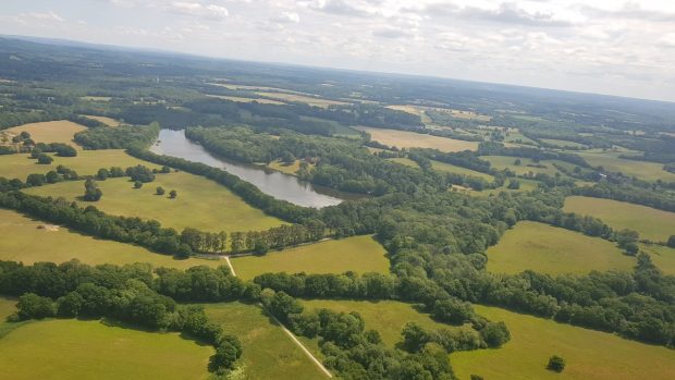 An ariel view of fields, woodland and lakes