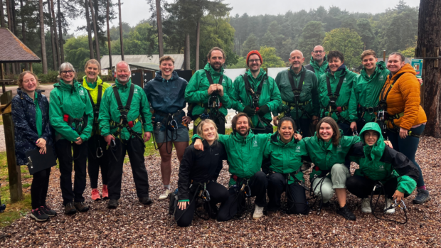 A group of forestry apprentices smiling at the camera in a forest.