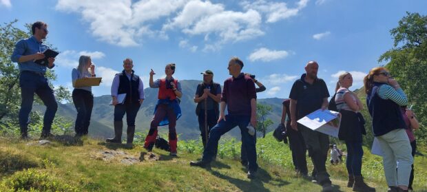 A group of people on a landscape design course standing on top of a hill